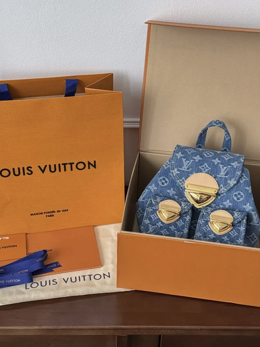 Джинсовый рюкзак рядом с фирменной коробкой и пакетом Louis Vuitton