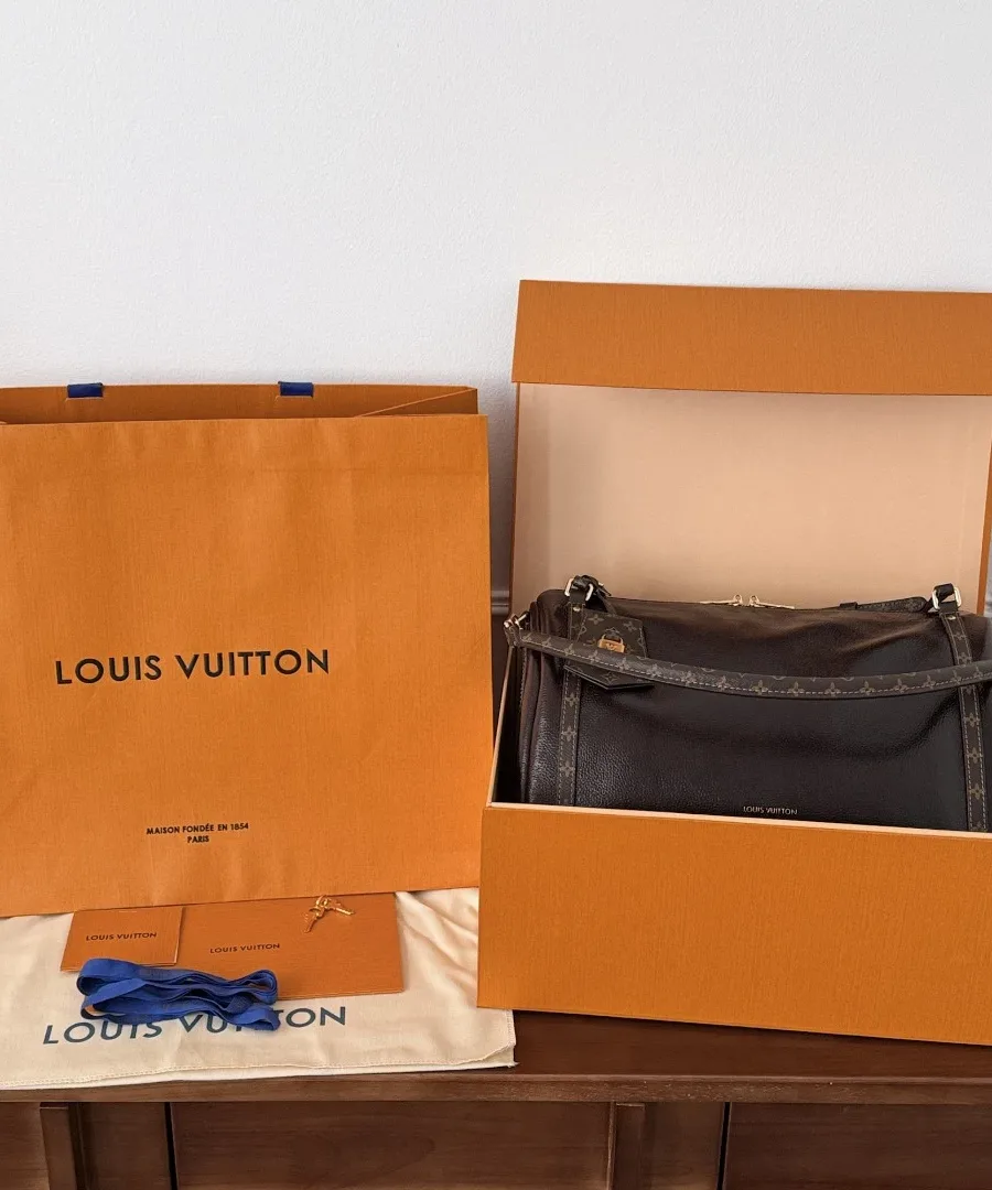 Сумка Louis Vuitton Express в фирменной оранжевой коробке рядом с пакетом