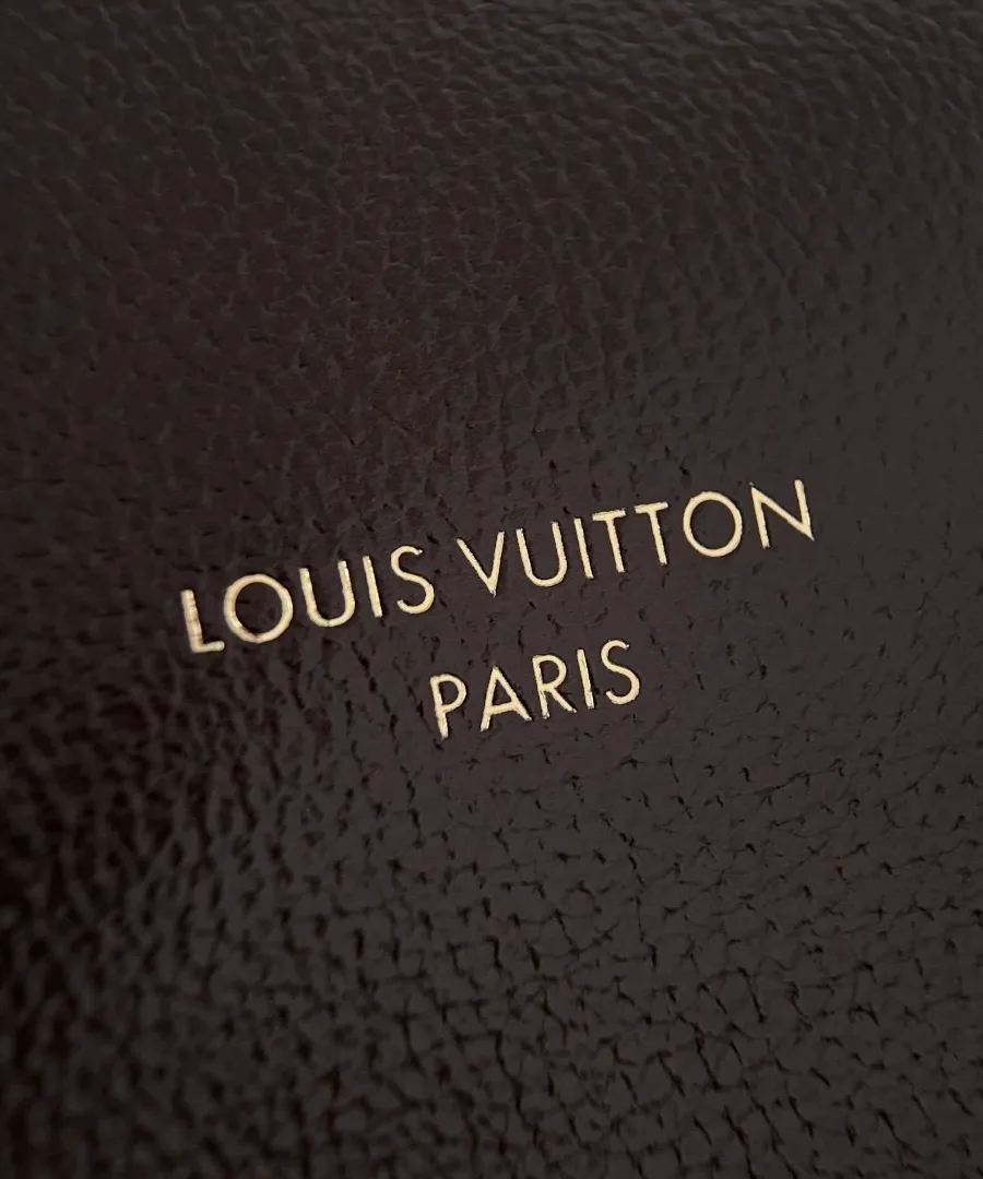 Золотистое тиснение логотипа Louis Vuitton Paris на коричневой коже