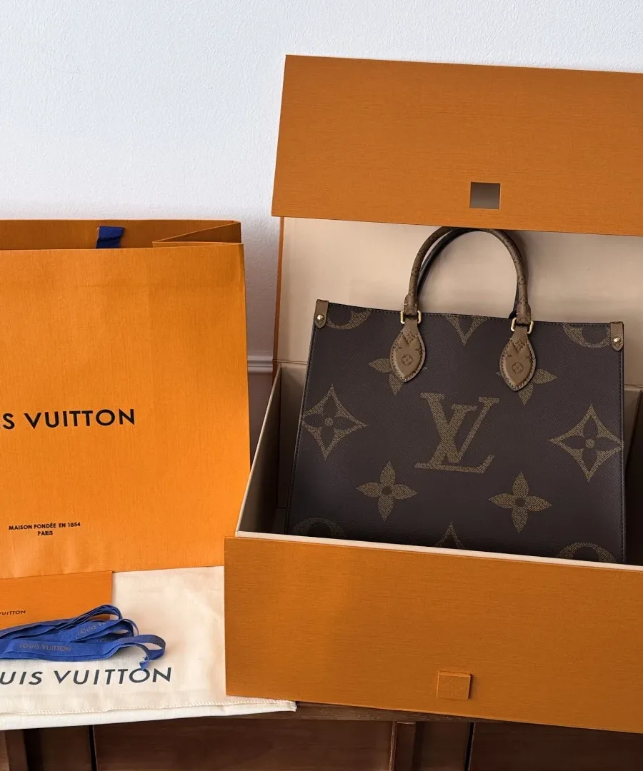 Сумка Louis Vuitton Onthego MM рядом с фирменной коробкой и пакетом