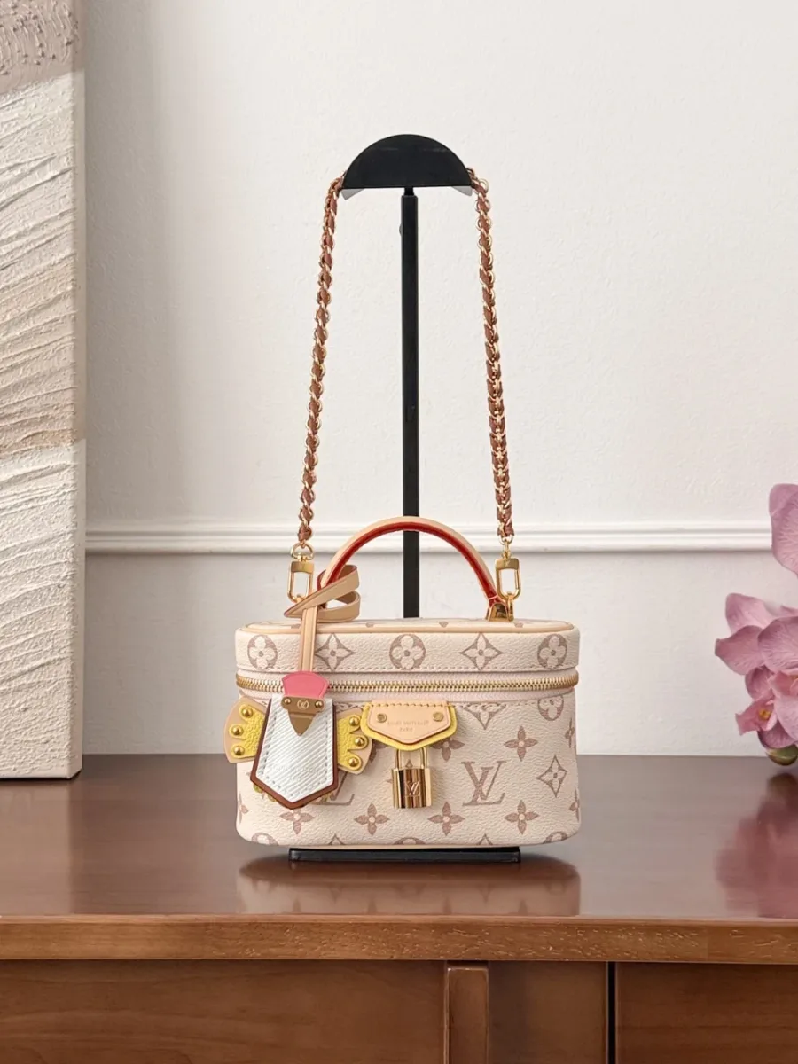 Сумка Vanity PM бежевого цвета с узором Monogram, вид спереди на подставке