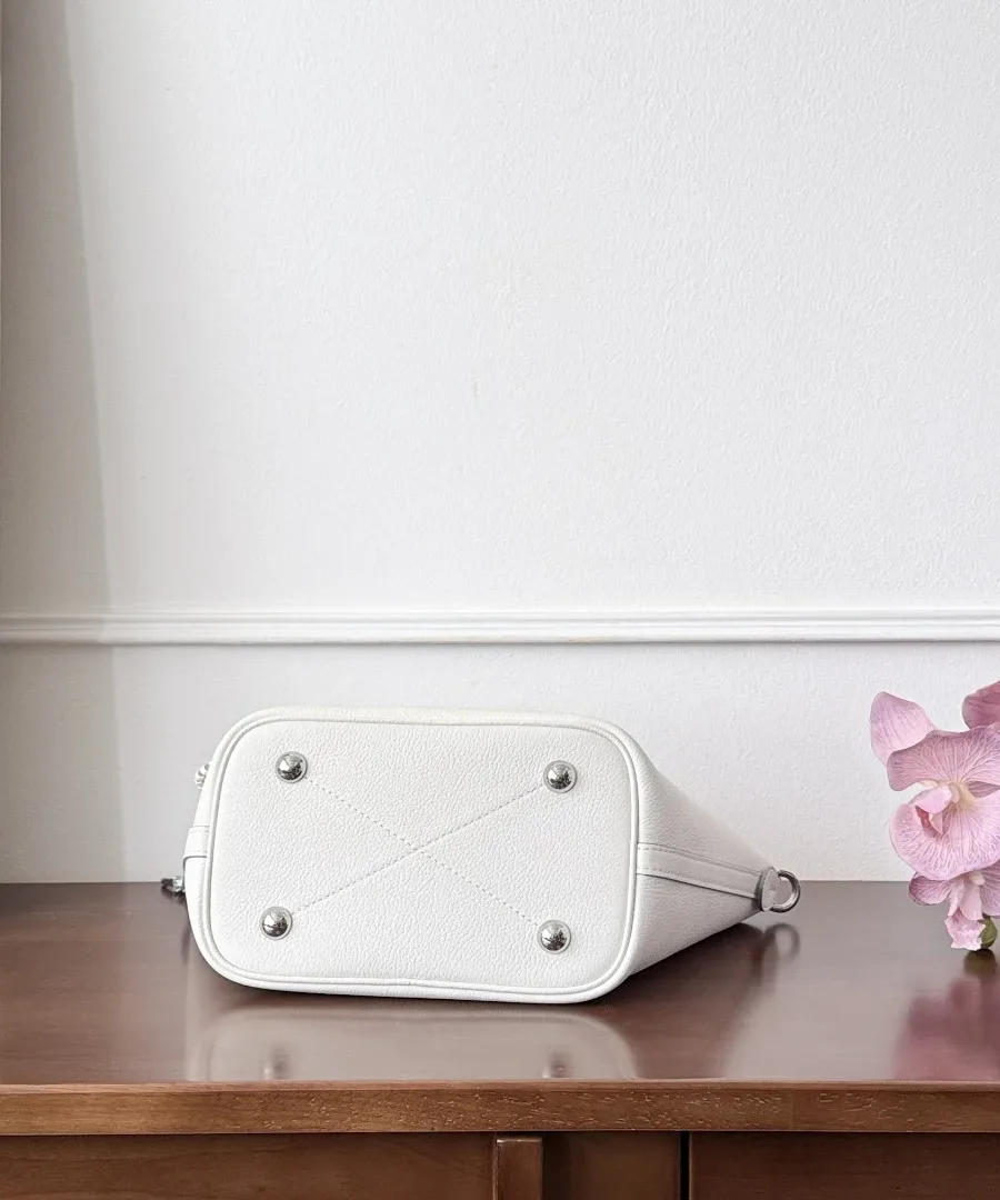 Дно белой кожаной сумки Louis Vuitton Blossom с четырьмя металлическими ножками