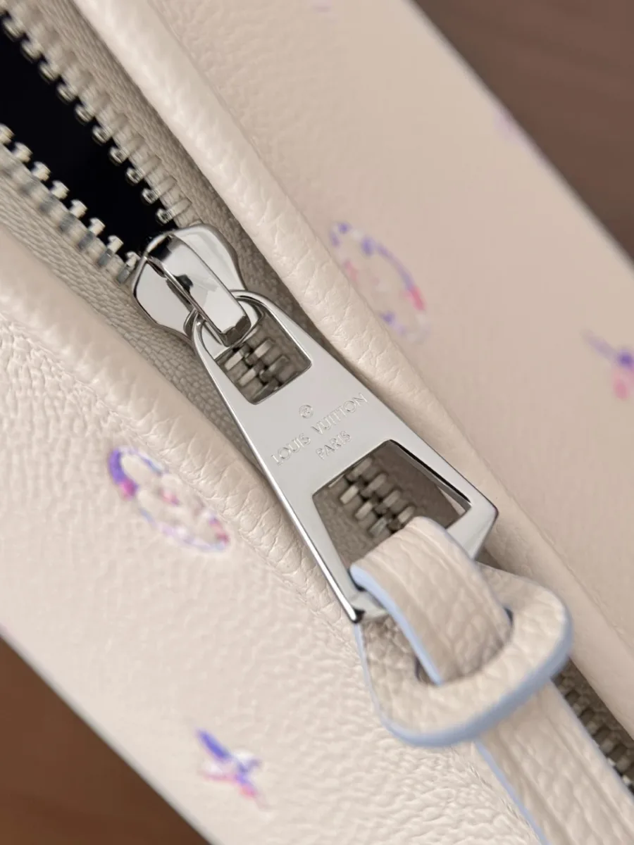 Крупный план металлической молнии бежевой сумки Louis Vuitton
