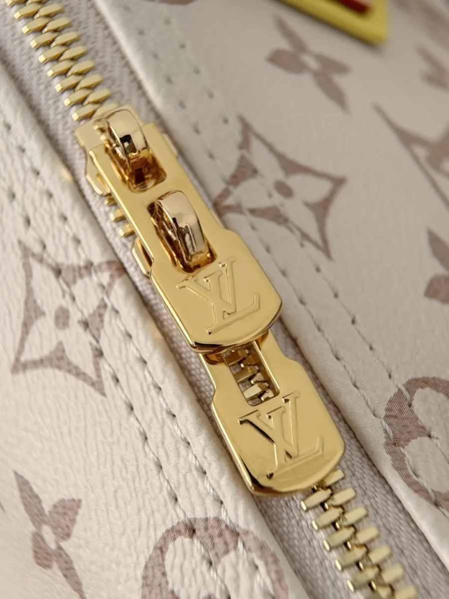 Крупный план двусторонней золотистой молнии с логотипами LV