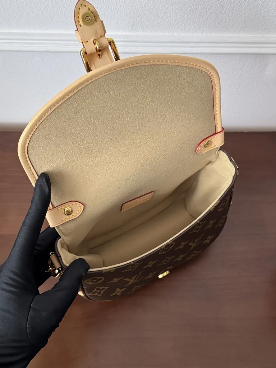 Открытая сумка Louis Vuitton Saumur BB, демонстрирующая внутреннее отделение и светлую подкладку
