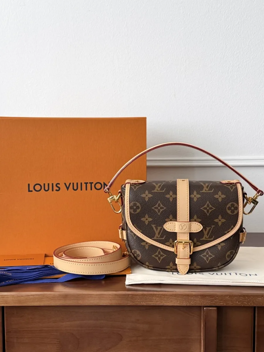 Сумка Louis Vuitton Saumur BB рядом с фирменной коробкой, пыльником и ремнями