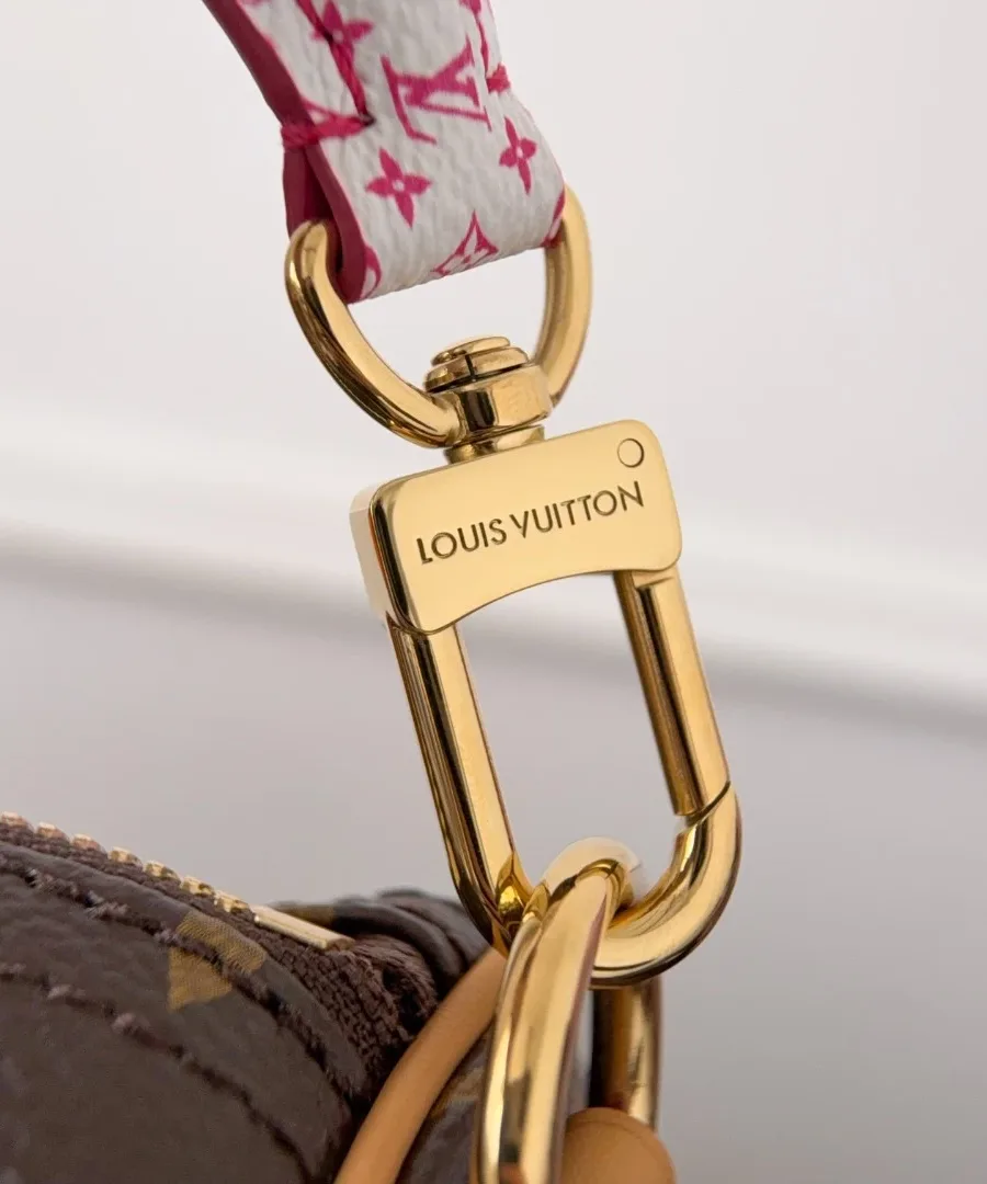Крупный план крепления плечевого ремня с гравировкой Louis Vuitton
