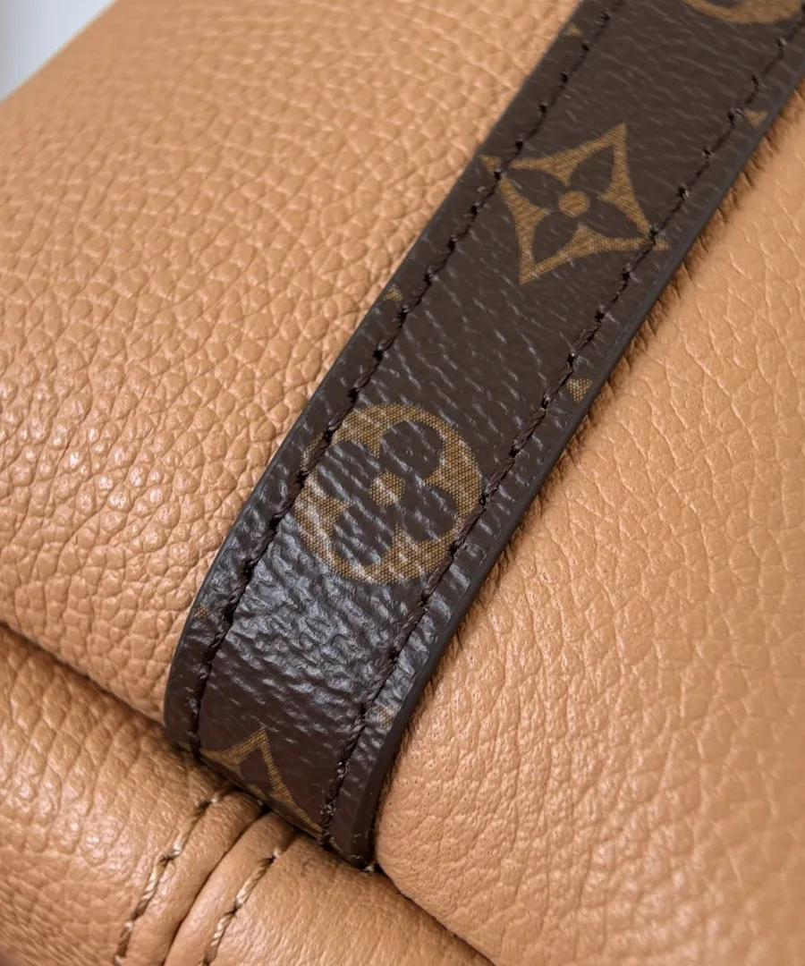 Деталь бокового шва со вставкой из канвы Monogram на фоне бежевой кожи