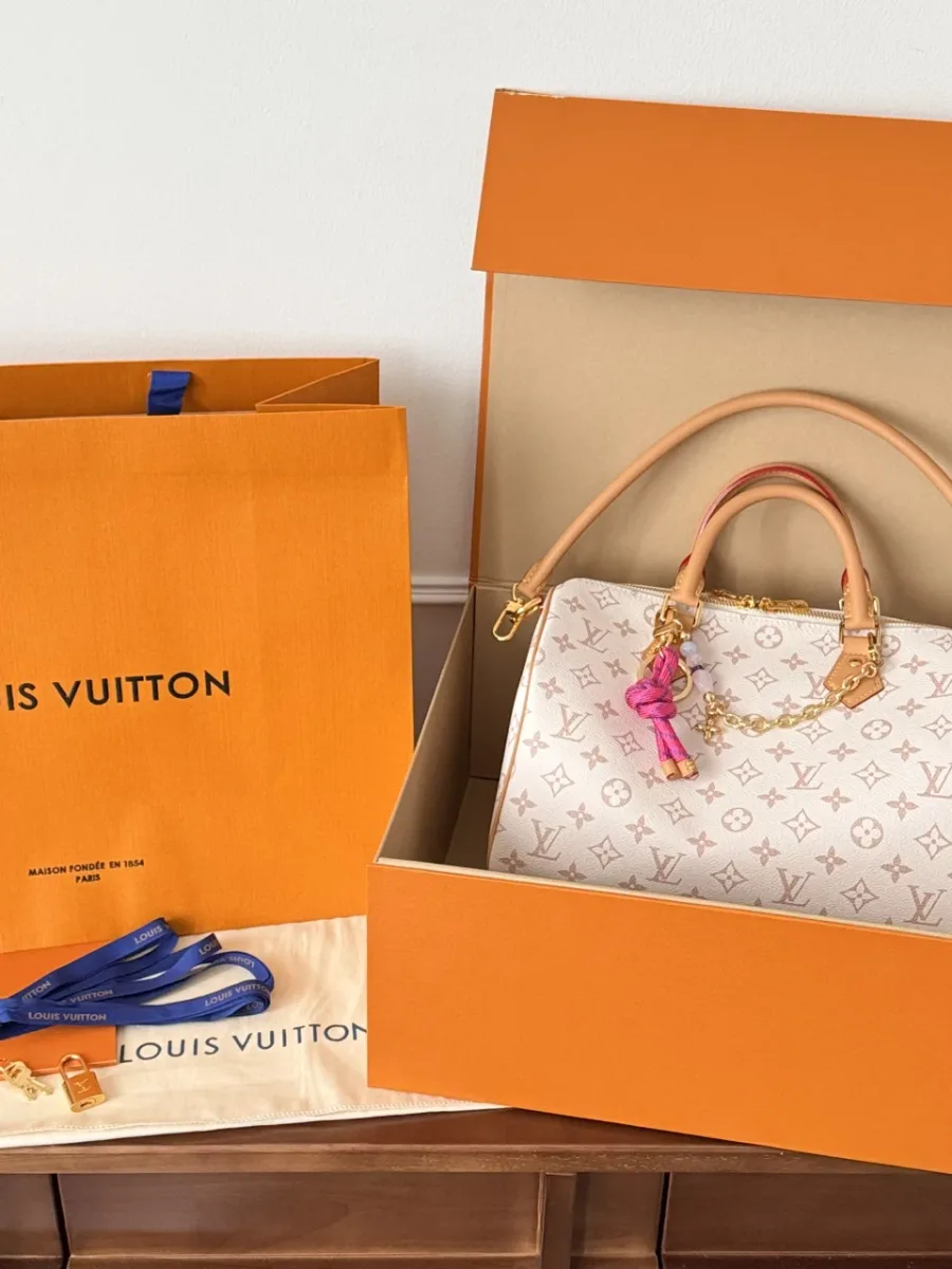 Сумка Louis Vuitton Speedy 30 в фирменной оранжевой коробке рядом с пакетом и пыльником