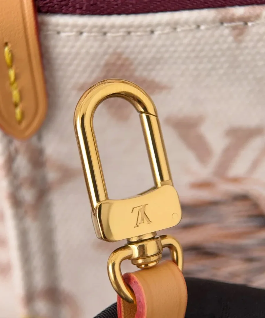 Золотистый карабин с гравировкой логотипа Louis Vuitton, крупный план