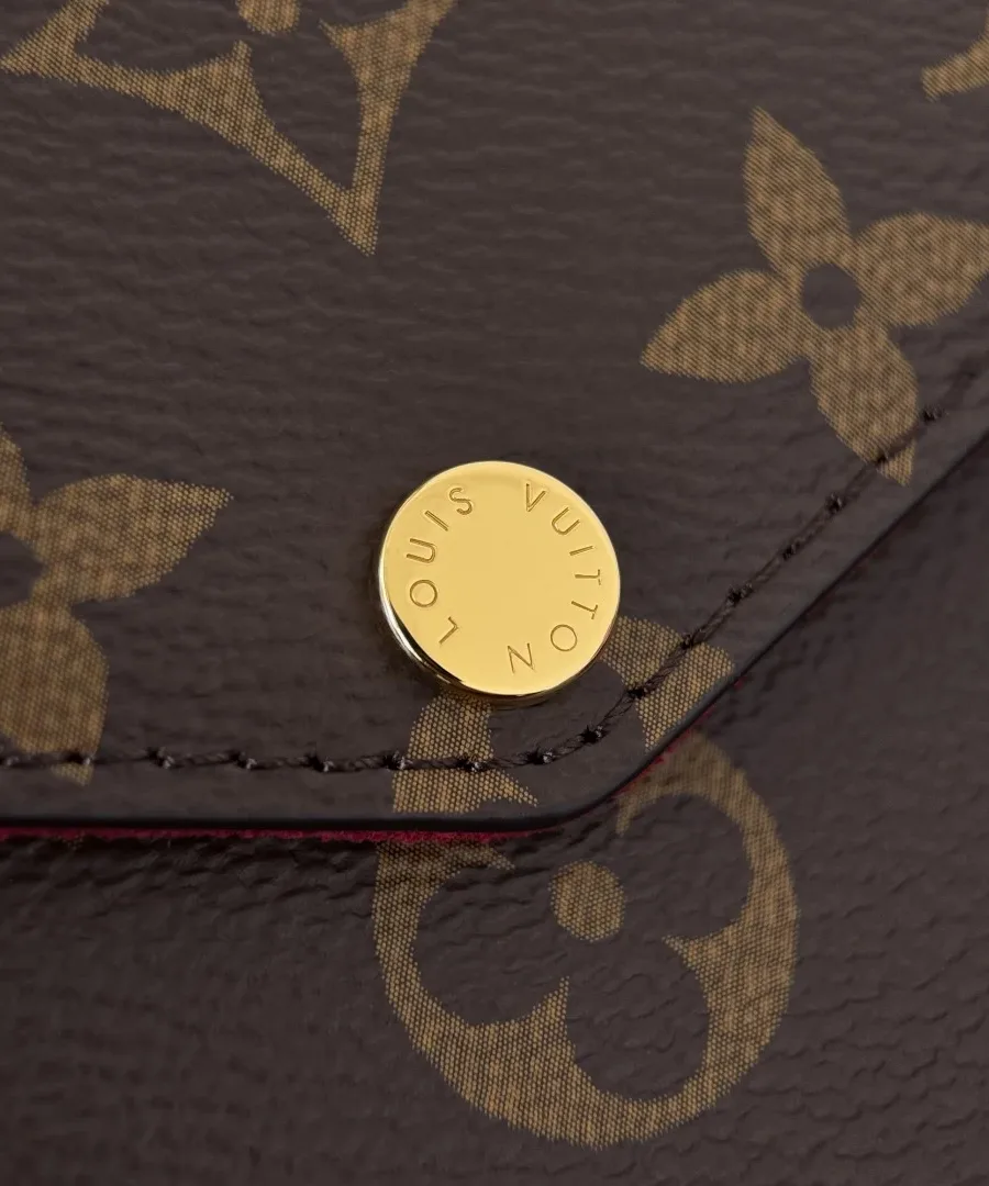 Крупный план золотистой кнопки-застежки с гравировкой Louis Vuitton