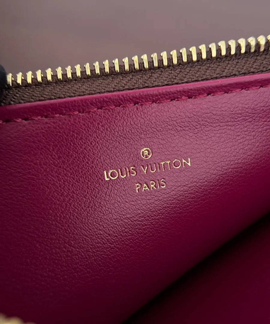 Крупный план золотистого тиснения Louis Vuitton Paris на съемном кошельке
