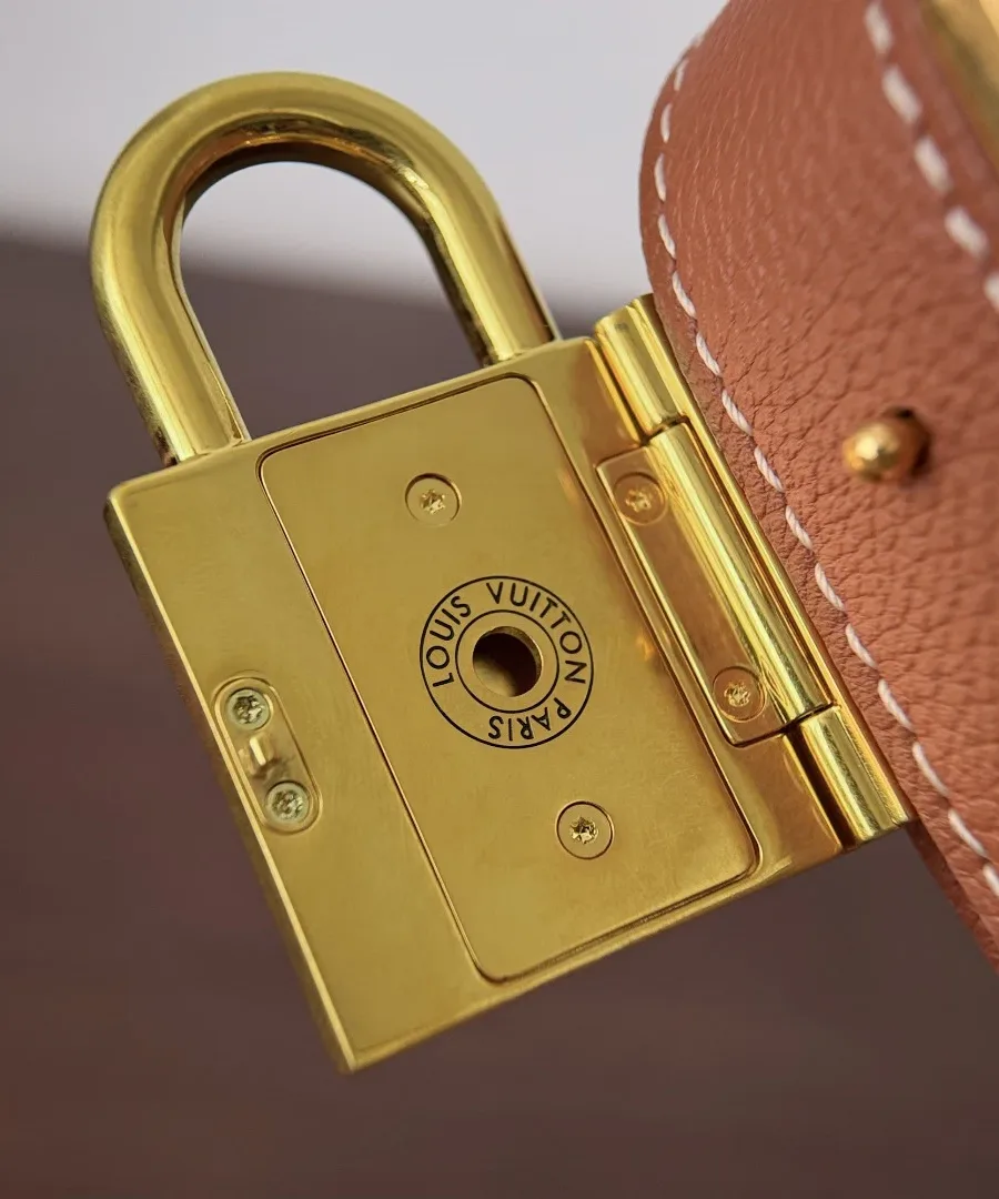 Обратная сторона золотистого замка с гравировкой Louis Vuitton Paris