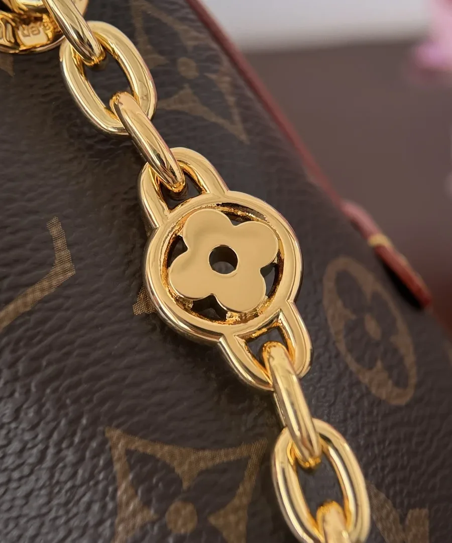 Крупный план золотистой цепочки с декоративным элементом в виде цветка Monogram