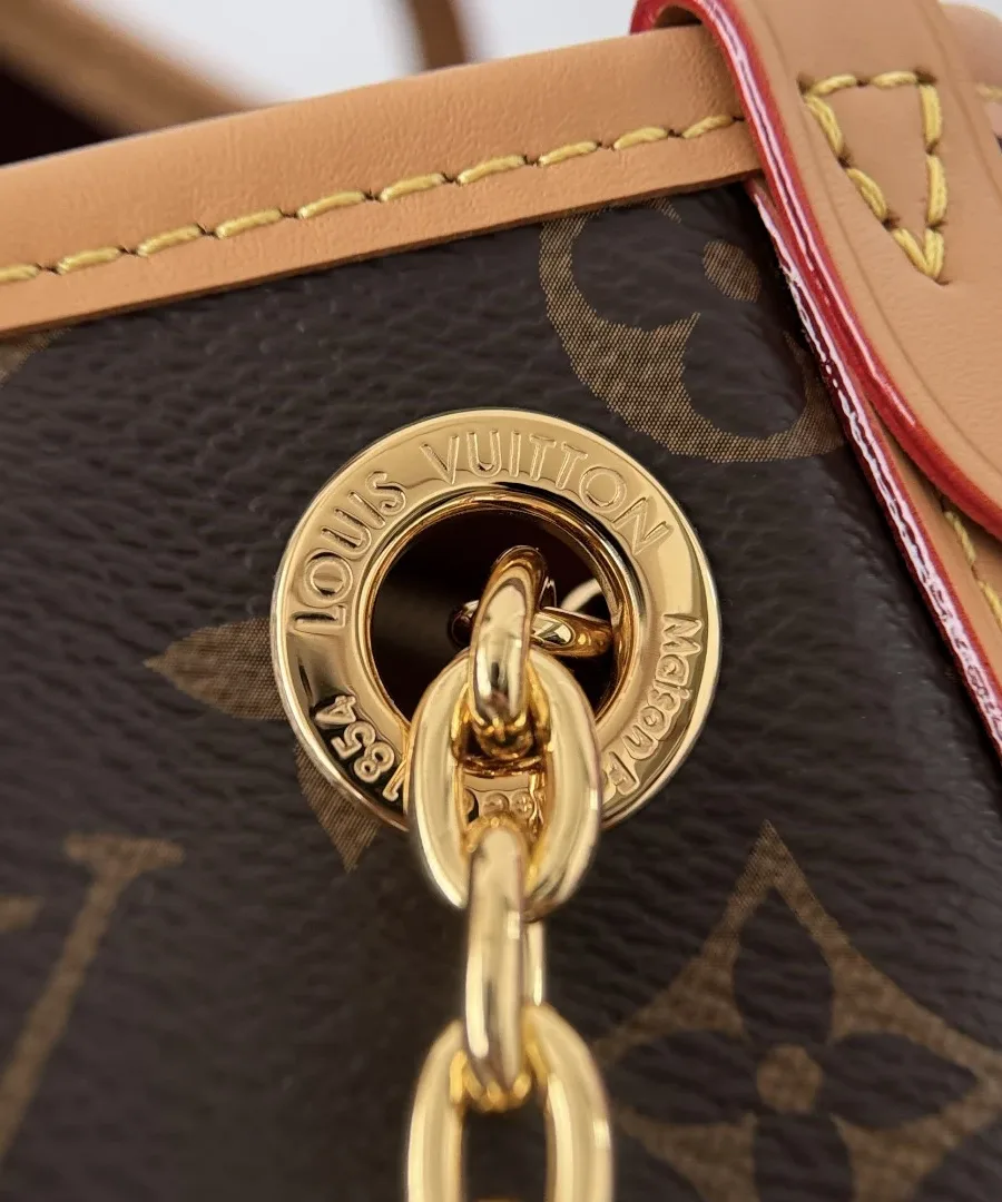 Крупный план золотистого люверса с гравировкой Louis Vuitton