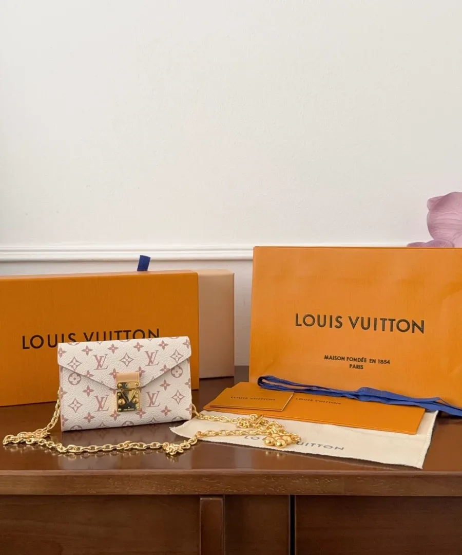 Микро-сумка Louis Vuitton Pochette Metis рядом с фирменной коробкой и пакетом