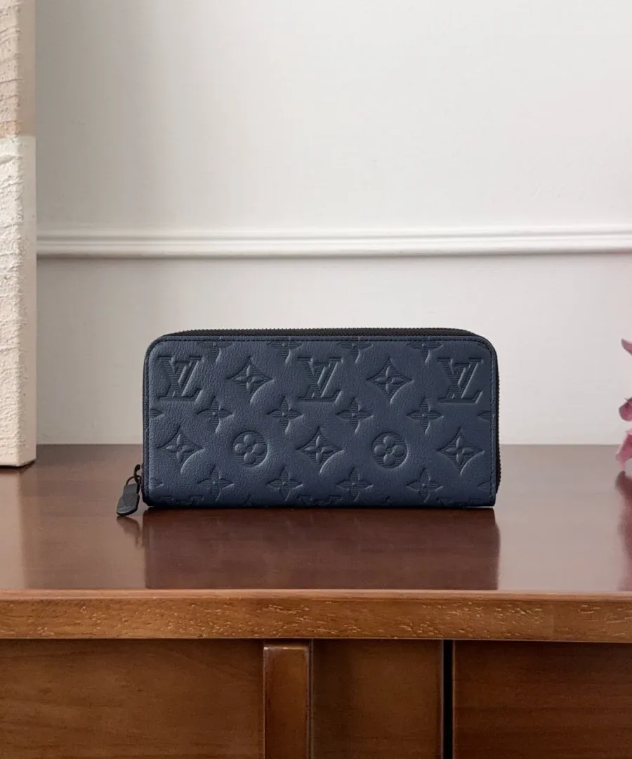 Темно-синее портмоне Louis Vuitton Zippy Horizontal на деревянной поверхности, вид спереди