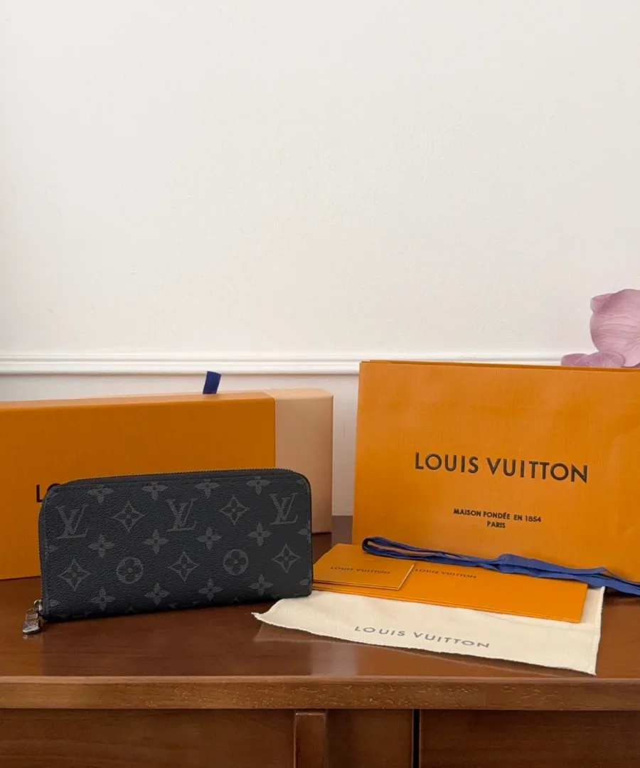 Темно-синее портмоне Louis Vuitton Zippy Horizontal рядом с фирменной коробкой и пыльником