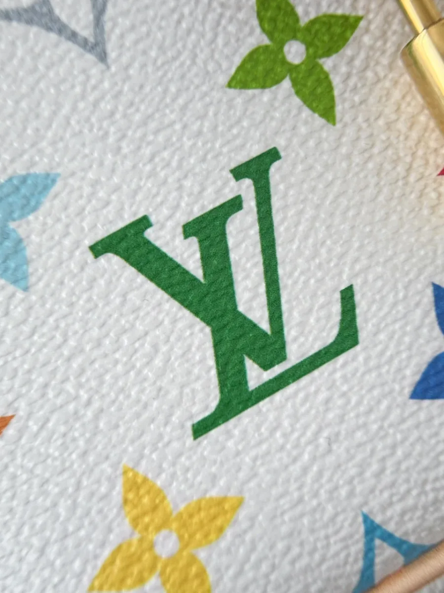 Крупный план фактурной белой канвы с зеленым логотипом LV и цветными цветами Monogram
