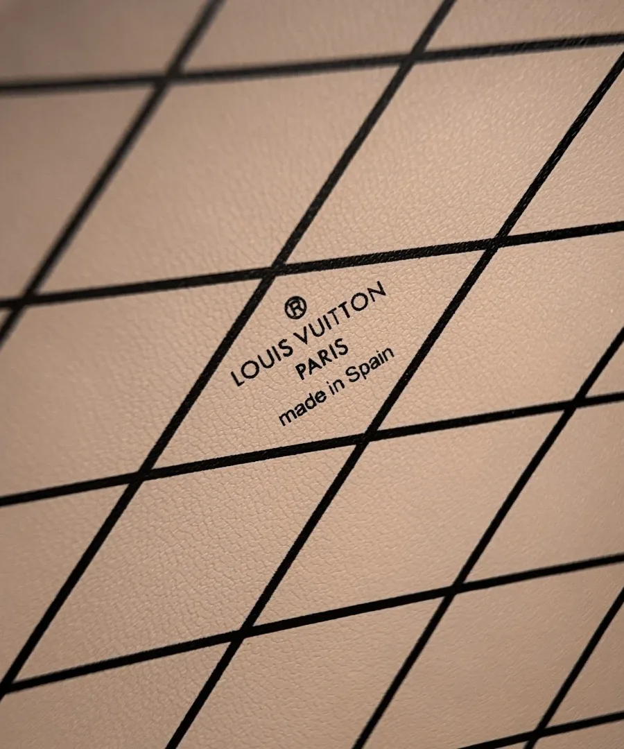 Крупный план внутренней отделки в бежевую клетку с надписью Louis Vuitton Paris