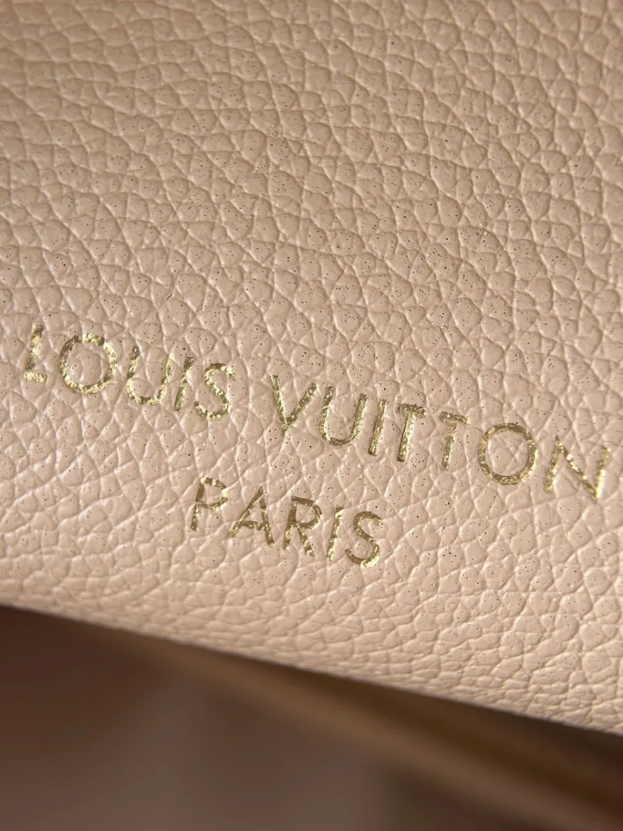 Крупный план золотистого тиснения Louis Vuitton Paris на коже