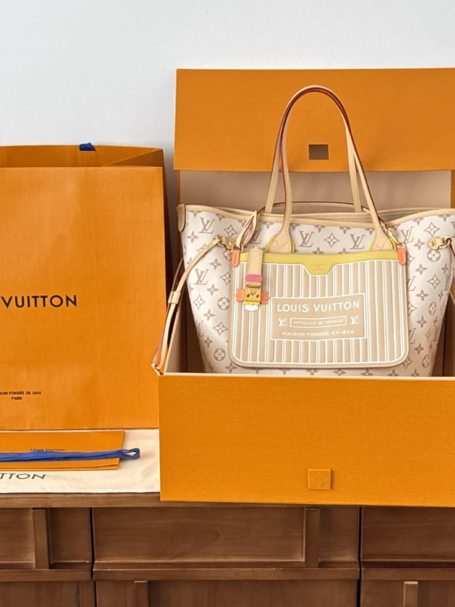 Сумка-тоут Louis Vuitton Neverfull MM рядом с фирменной коробкой и пакетом
