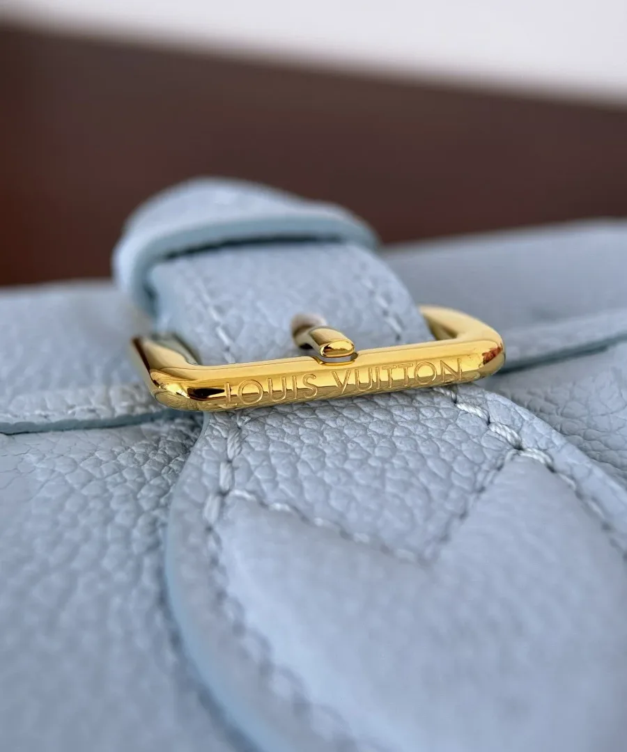 Золотистая пряжка с гравировкой Louis Vuitton на ремешке сумки