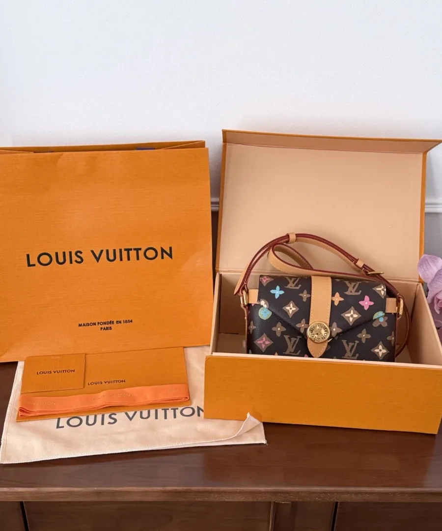Разноцветная сумка Louis Vuitton рядом с фирменной коробкой и пакетом