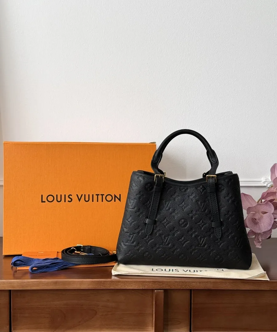 Черная сумка Louis Vuitton Babylone рядом с фирменной оранжевой коробкой и пыльником