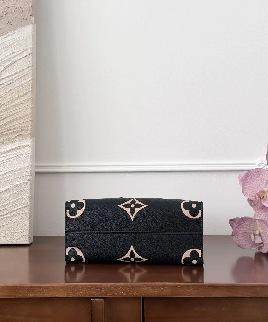 Нижняя часть черной сумки-тоут Louis Vuitton OnTheGo PM с монограммным узором
