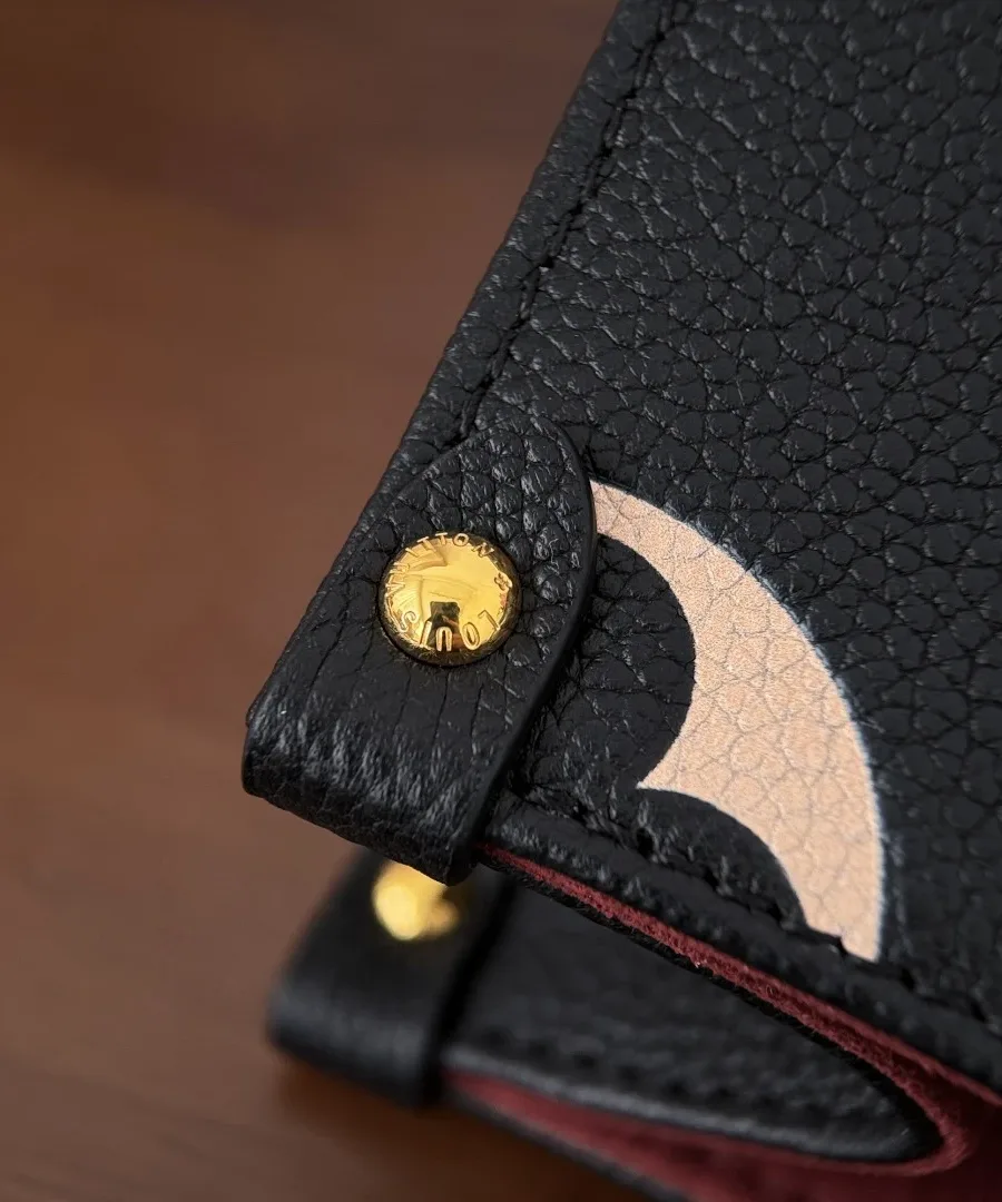 Крупный план угла сумки Louis Vuitton OnTheGo PM с золотистой металлической ножкой