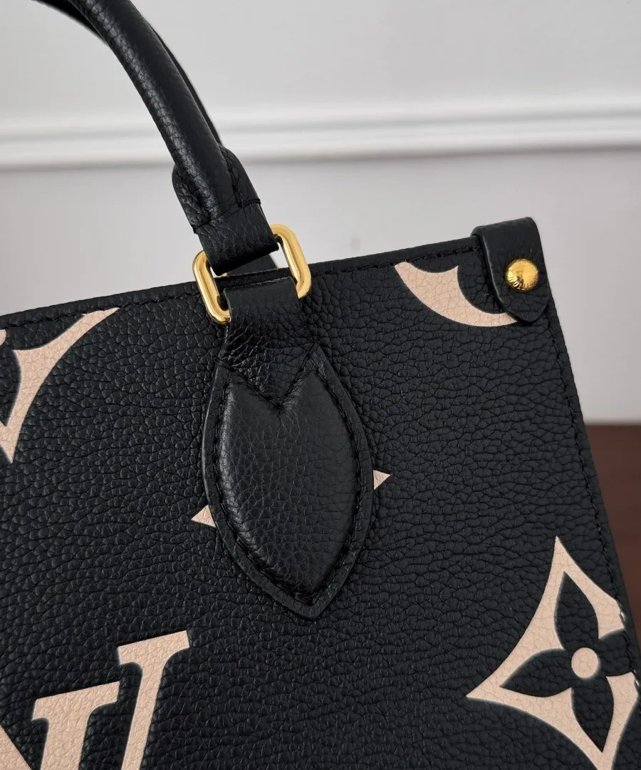 Деталь крепления кожаной ручки к корпусу сумки Louis Vuitton OnTheGo PM с золотистым кольцом