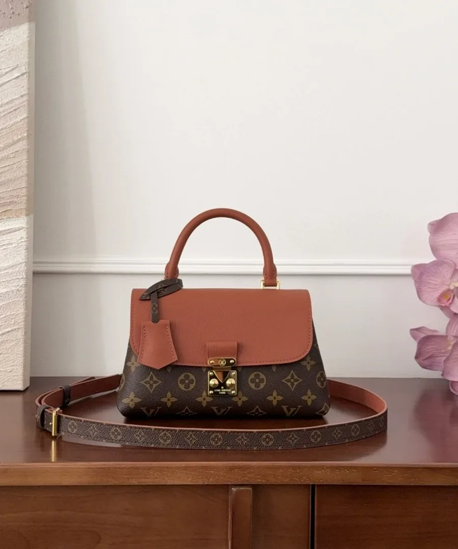 Коричневая сумка Louis Vuitton Madelene BB на столе, вид спереди с плечевым ремнем