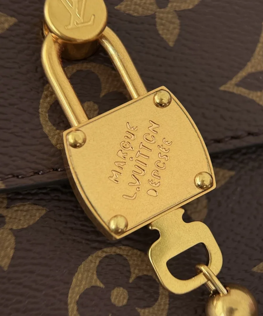 Крупный план золотистого замка с гравировкой Louis Vuitton