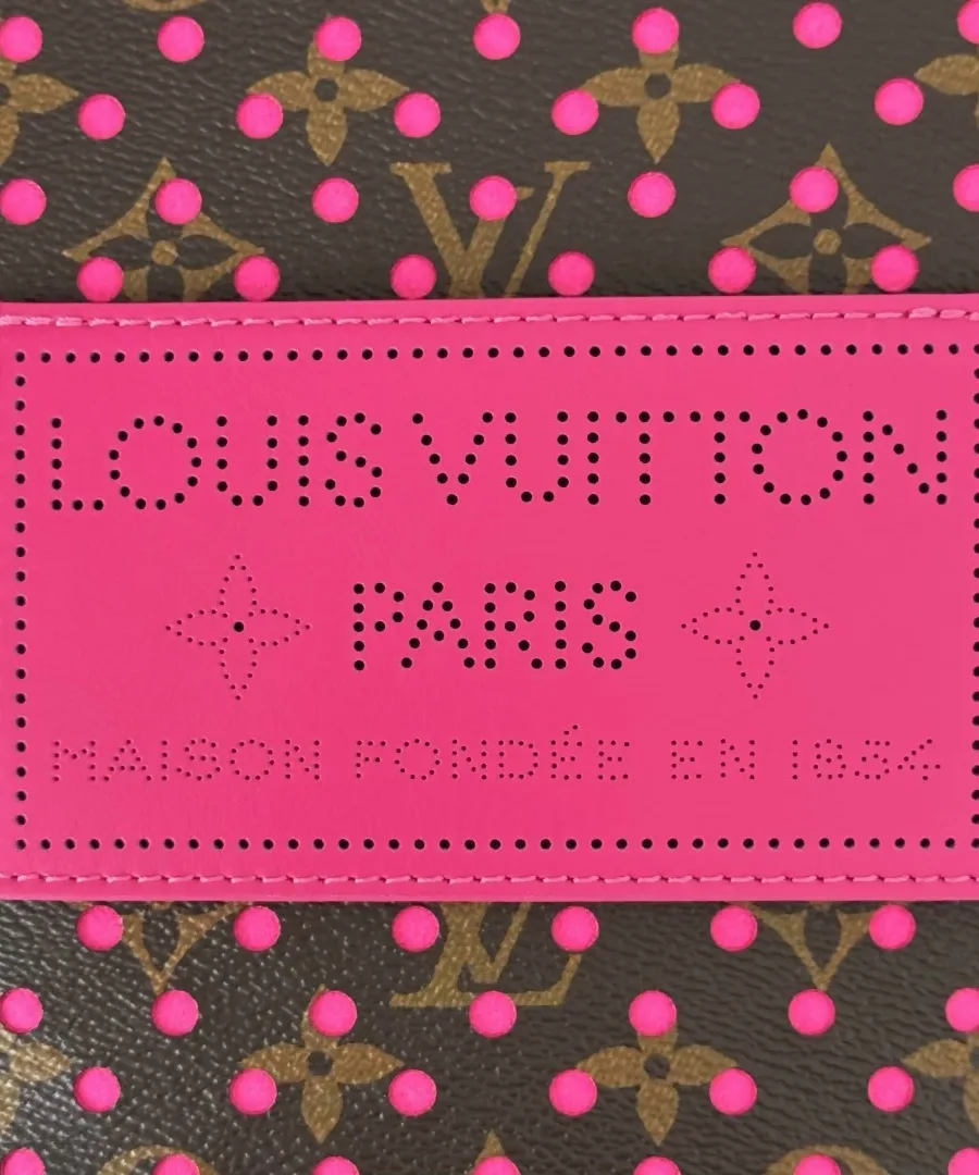 Крупный план розовой кожаной нашивки с перфорированной надписью Louis Vuitton Paris