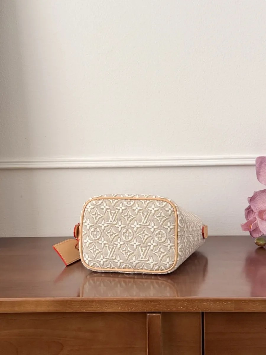 Вид снизу на овальное дно бежевой сумки-ведра Louis Vuitton.