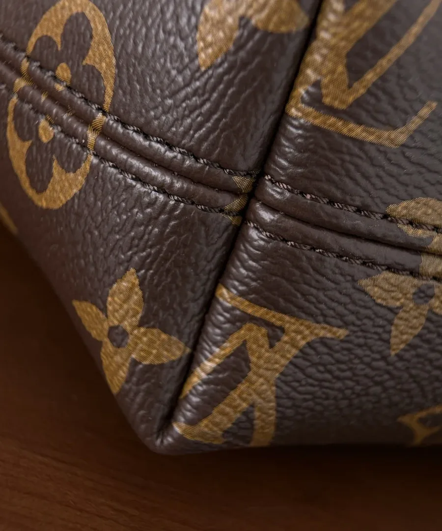 Крупный план швов и текстуры канвы Monogram на углу сумки Bento Box