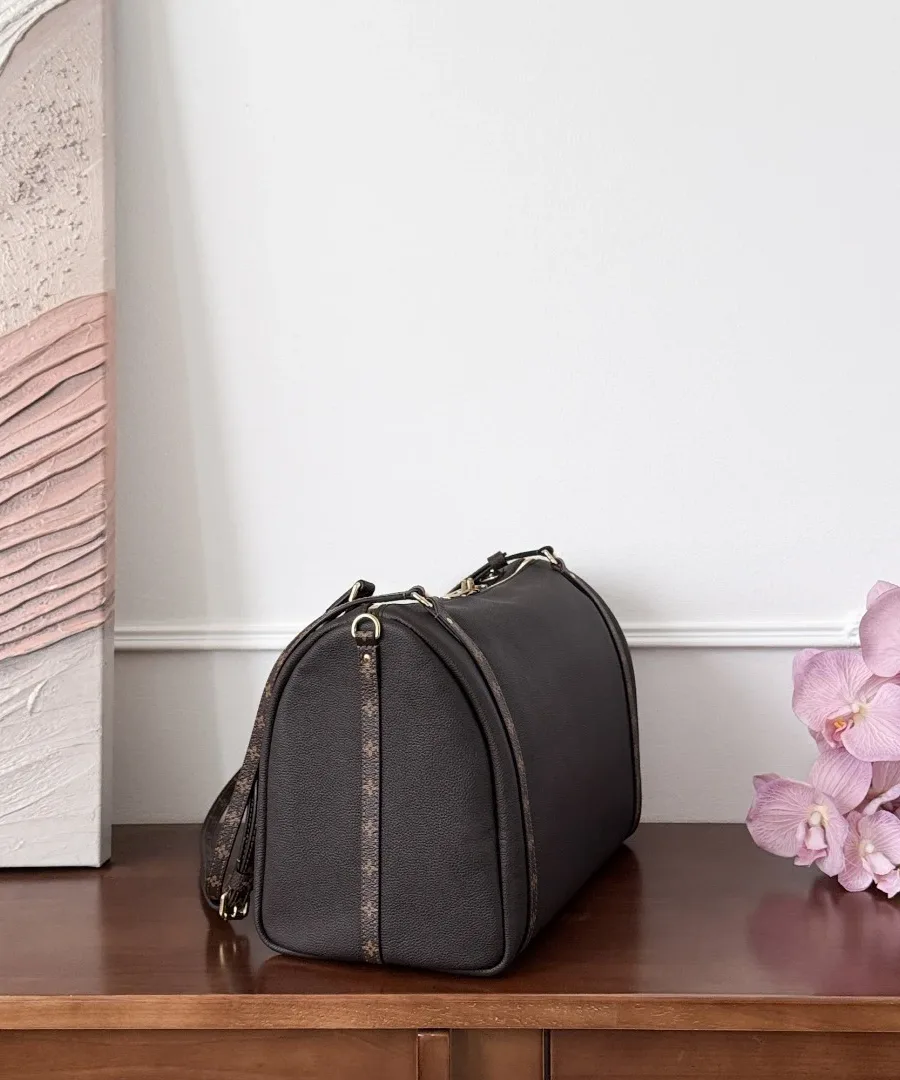 Вид сбоку на темно-коричневую сумку Louis Vuitton Express цилиндрической формы