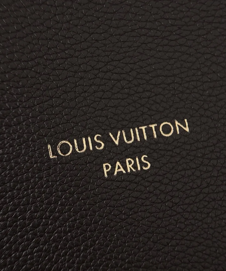 Крупный план золотистого тиснения логотипа Louis Vuitton Paris на коже