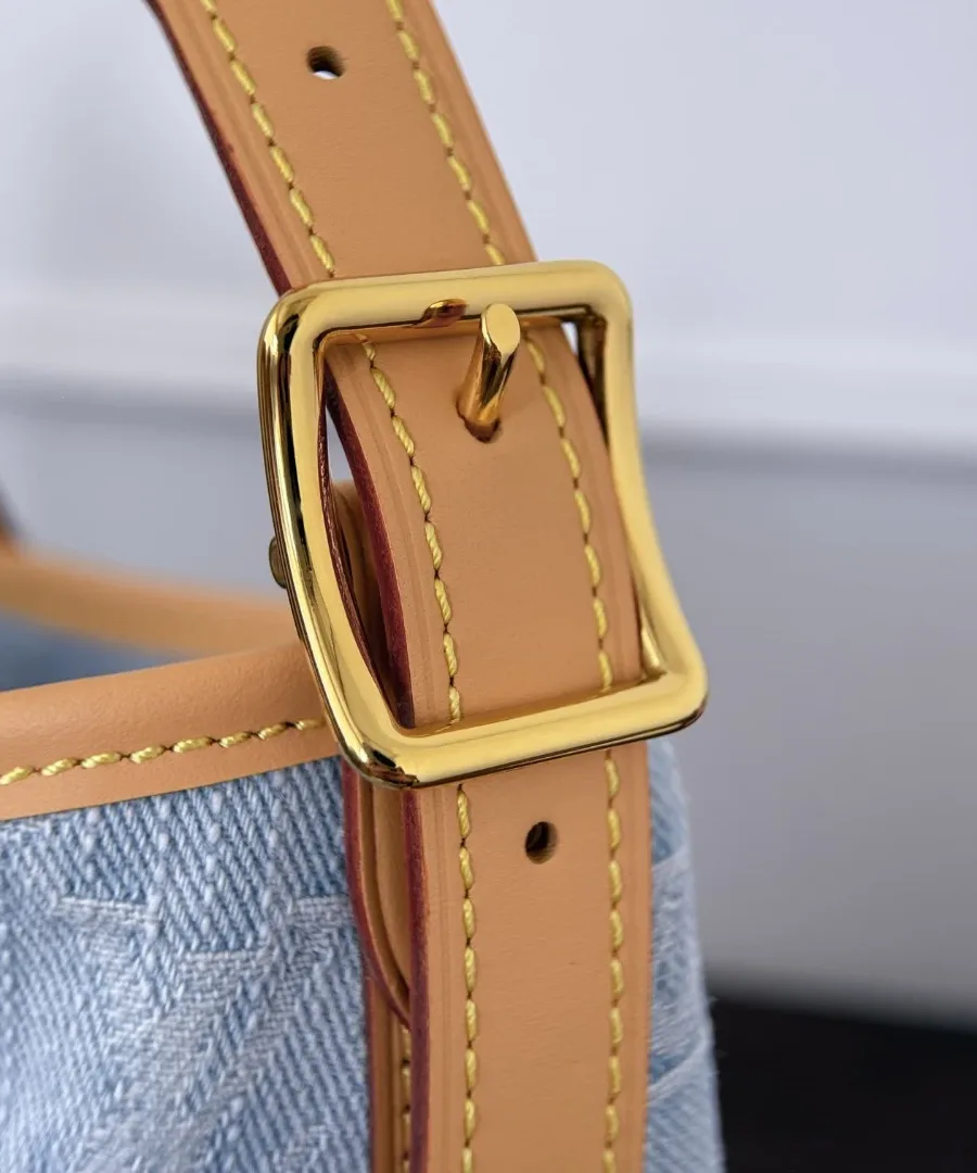 Золотистая пряжка на кожаном ремне голубой джинсовой сумки CarryAll PM