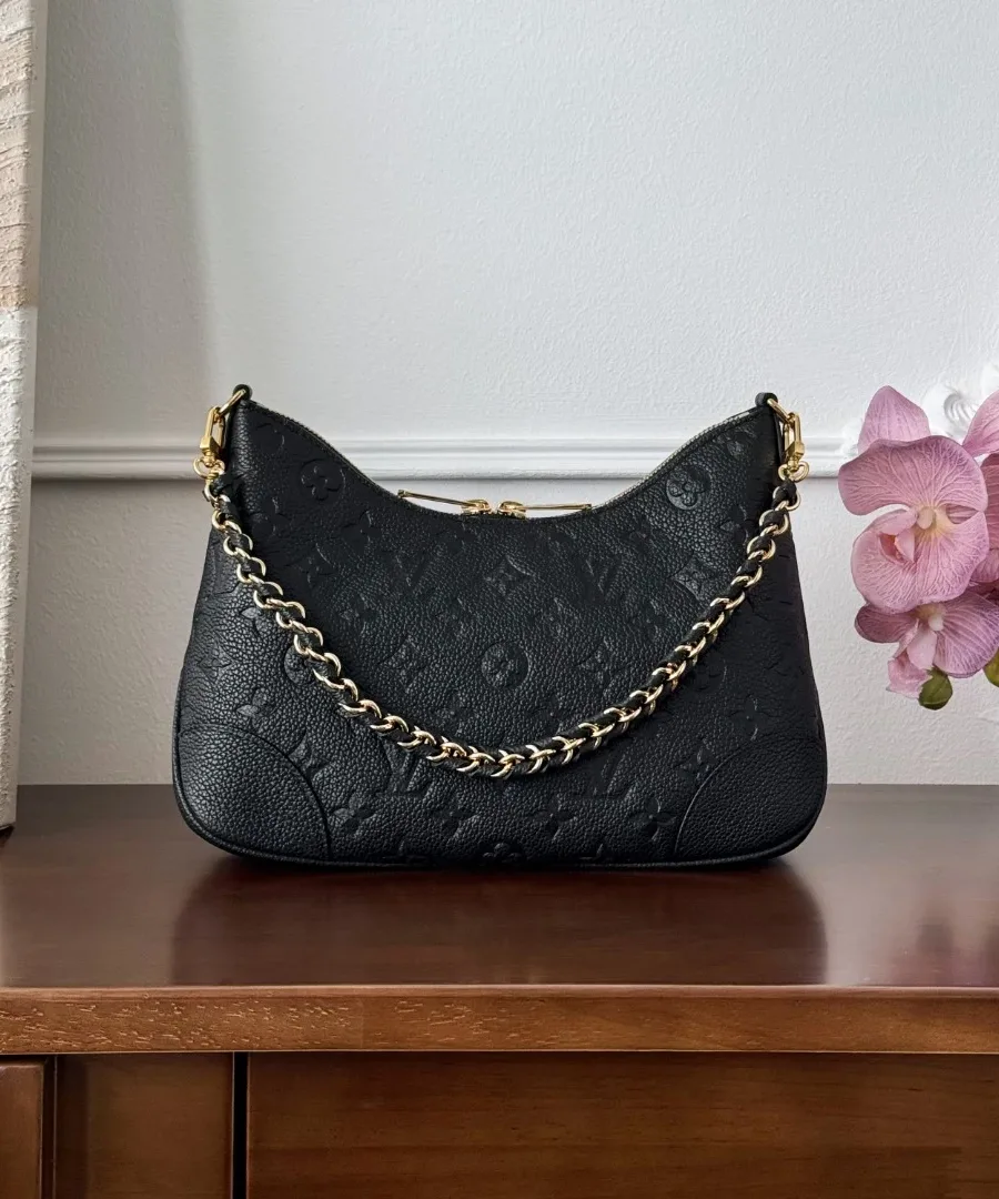 Чёрная сумка Louis Vuitton Boulogne с золотистой цепочкой на фоне цветов, вид спереди