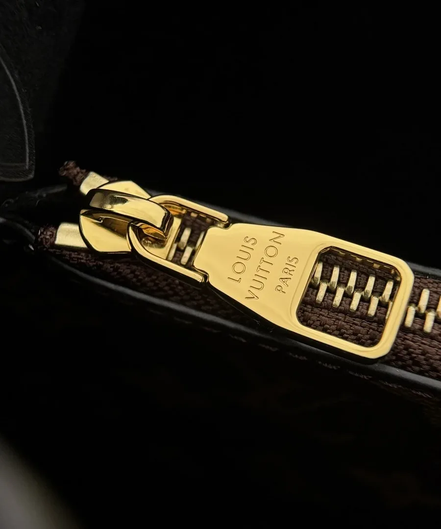 Крупный план золотистой молнии внутреннего кармана с гравировкой Louis Vuitton