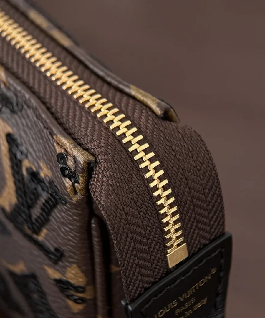 Крупный план застежки-молнии и шва сумки Louis Vuitton Pochette Accessoires