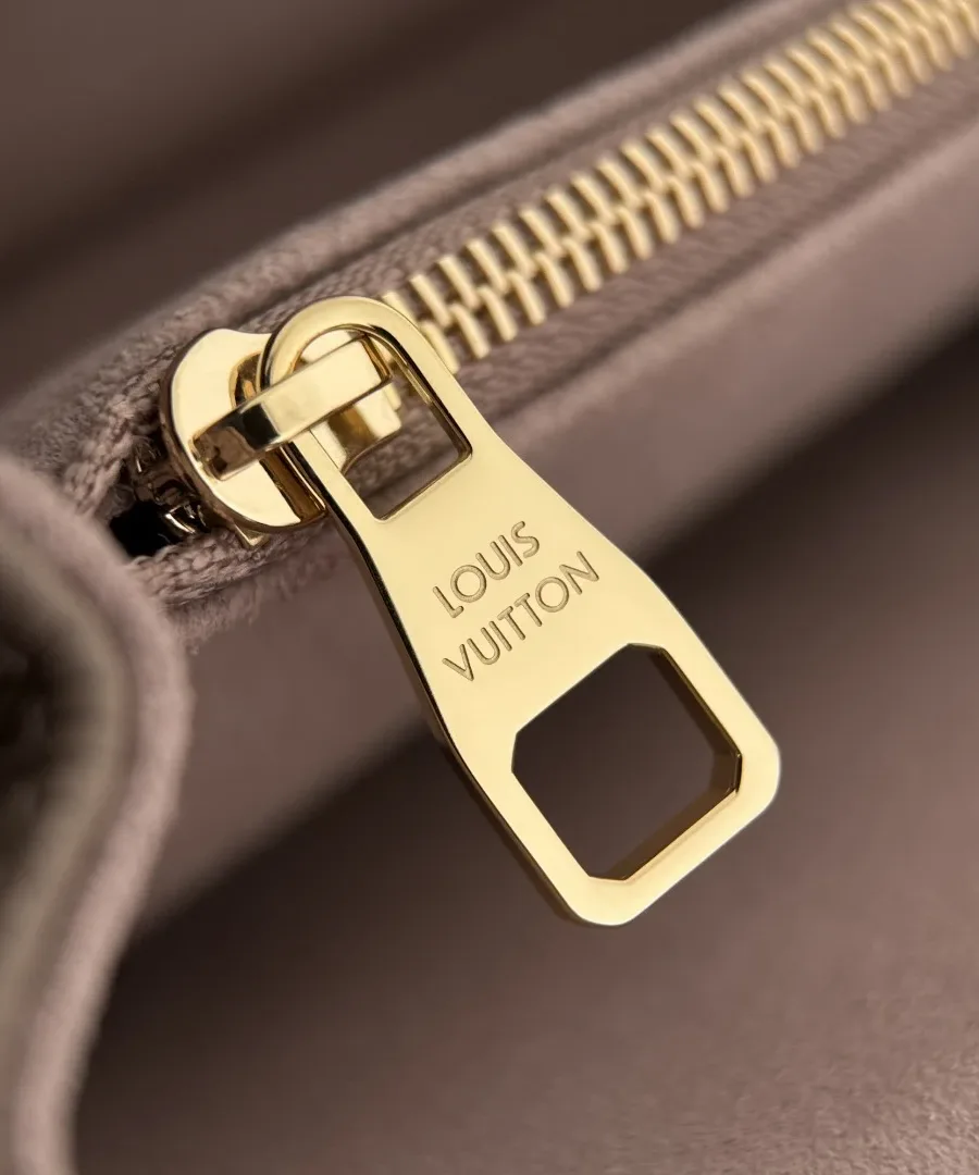 Золотистый пуллер молнии с гравировкой Louis Vuitton внутри сумки