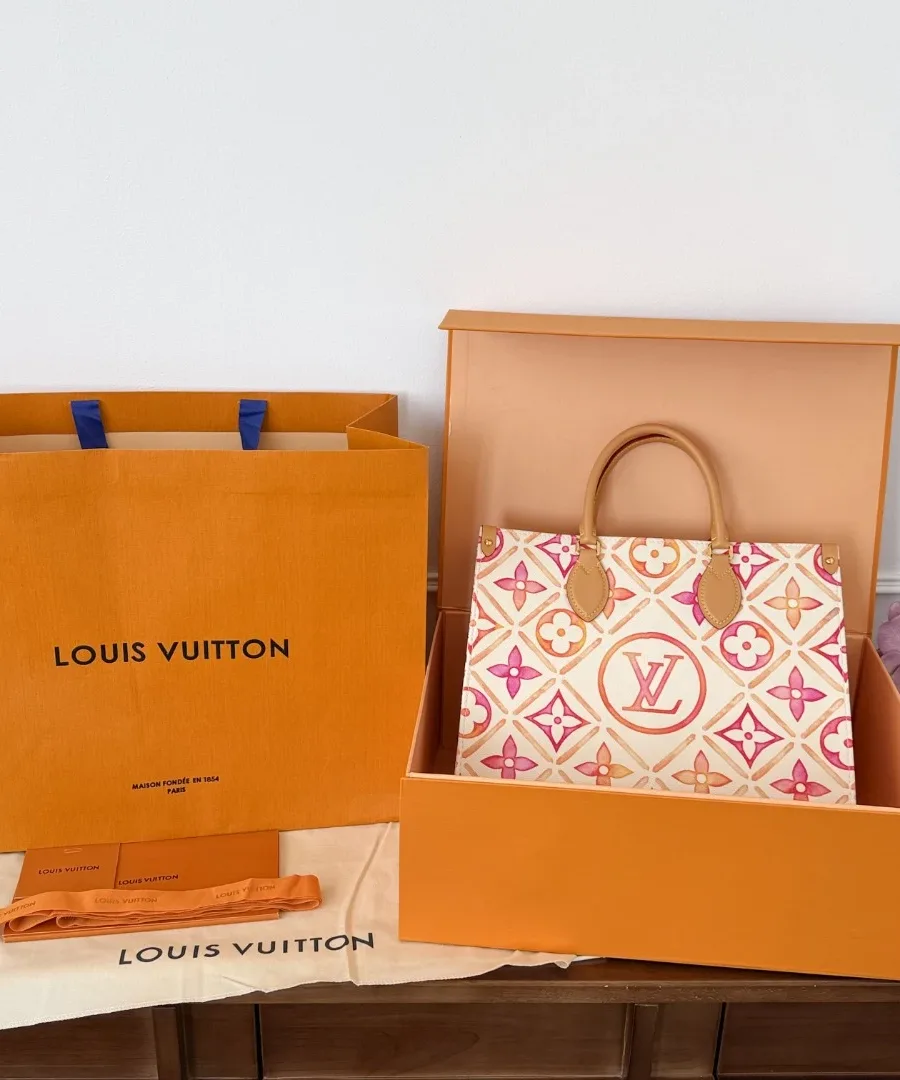 Сумка Louis Vuitton OnTheGo MM рядом с фирменной коробкой и пакетом