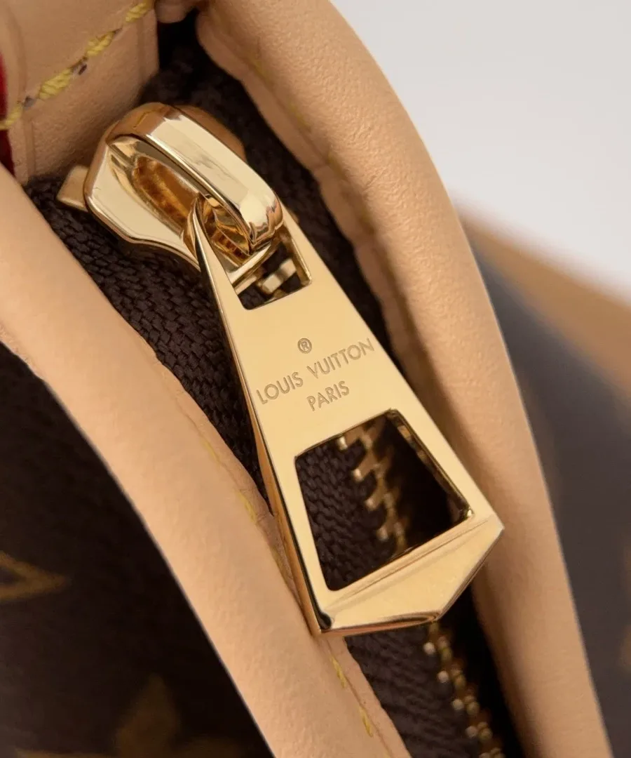 Крупный план золотистой застежки-молнии с гравировкой Louis Vuitton Paris