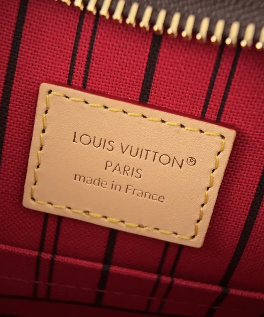 Крупный план внутренней кожаной нашивки Louis Vuitton Paris на красной подкладке