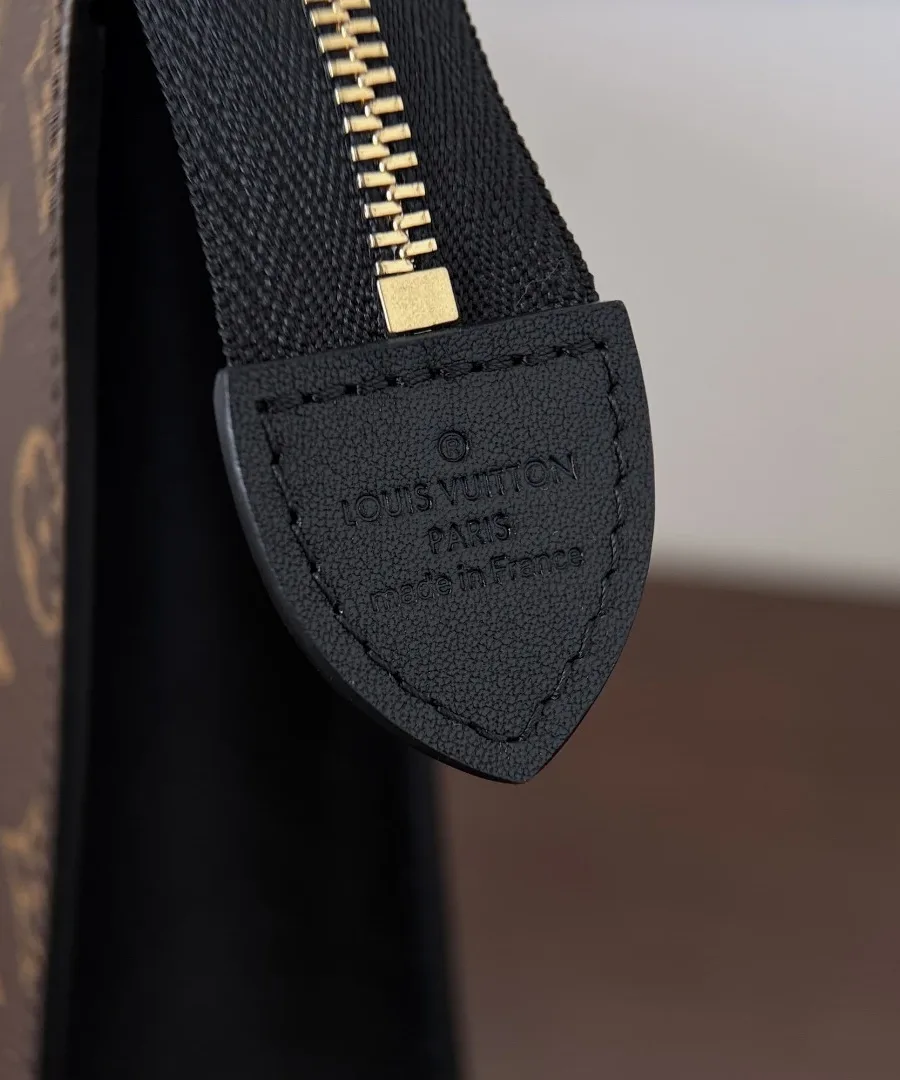 Крупный план черного кожаного ярлыка с тиснением Louis Vuitton Paris на конце молнии