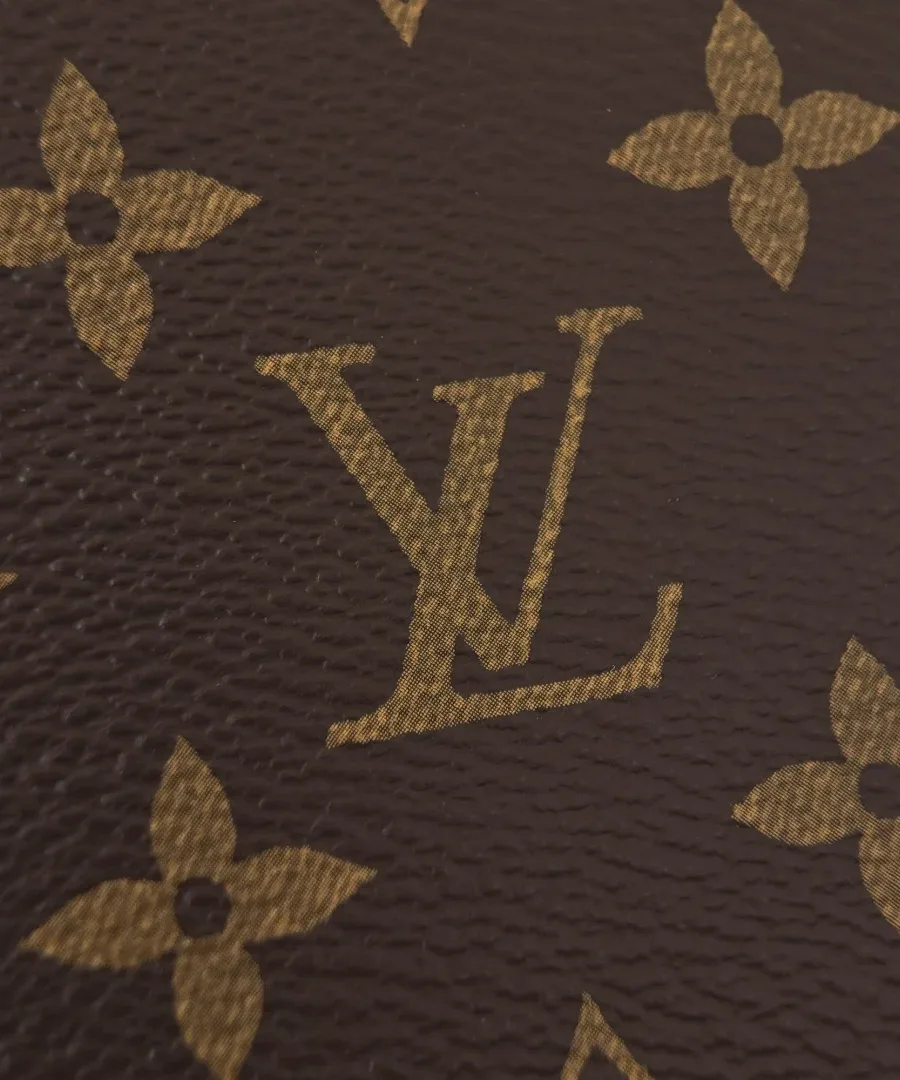 Текстура коричневой канвы Monogram с фирменным золотистым логотипом бренда LV