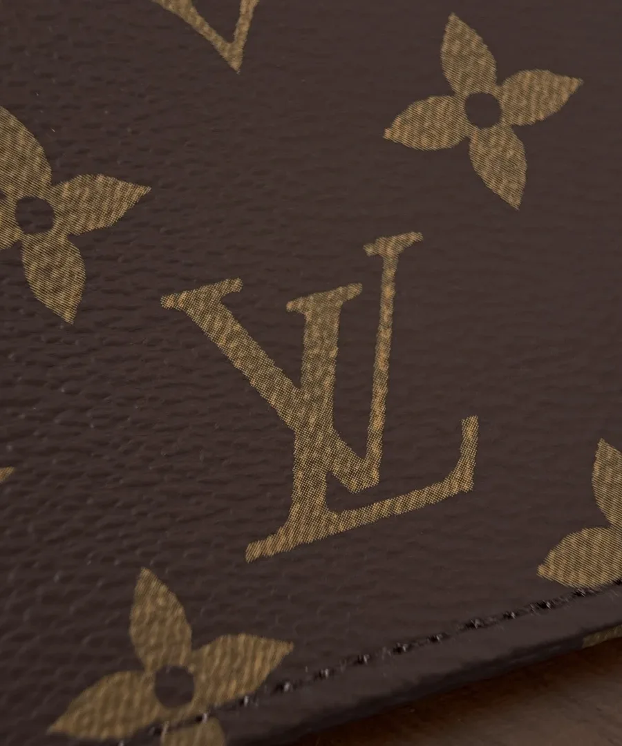 Деталь аккуратного шва и текстуры коричневой канвы Monogram крупным планом
